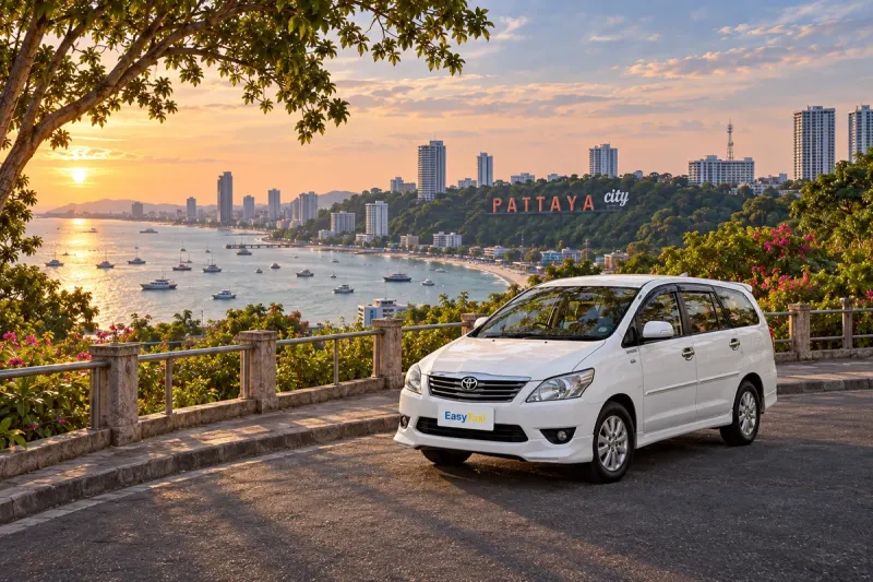 White Bangkok Pattaya Taxi Toyota Innova overlooking Pattaya Bay and the Pattaya City hillside sign